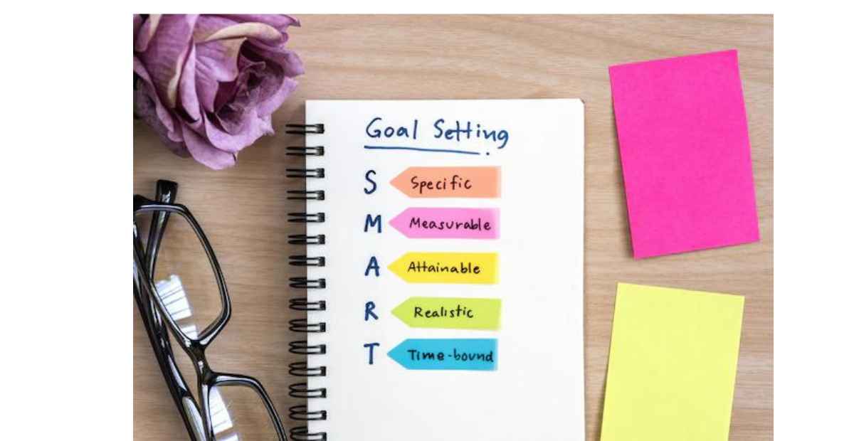 Set project goals | a journal with goals written on  it on a desk with a pair of glasses and sticker notes on it. 