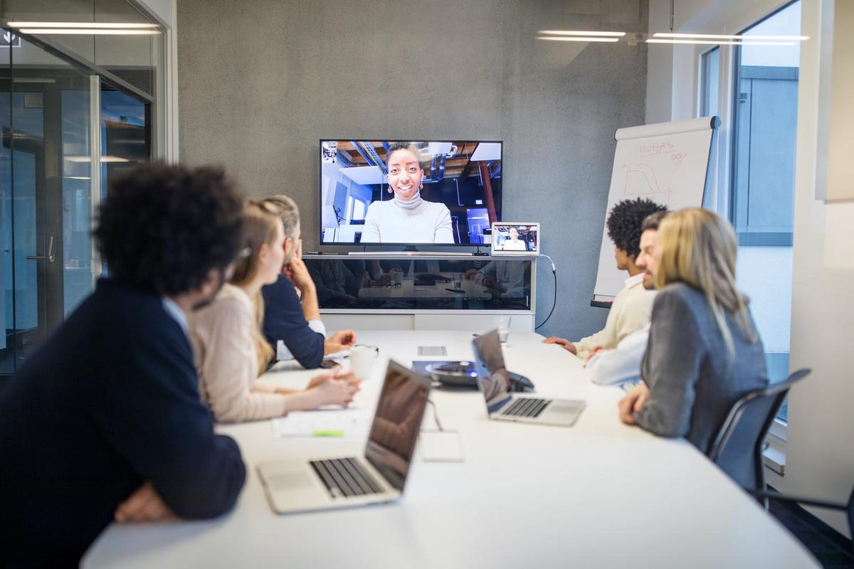 Set up beyond-work virtual spaces | Employees in work meeting in a conference room.